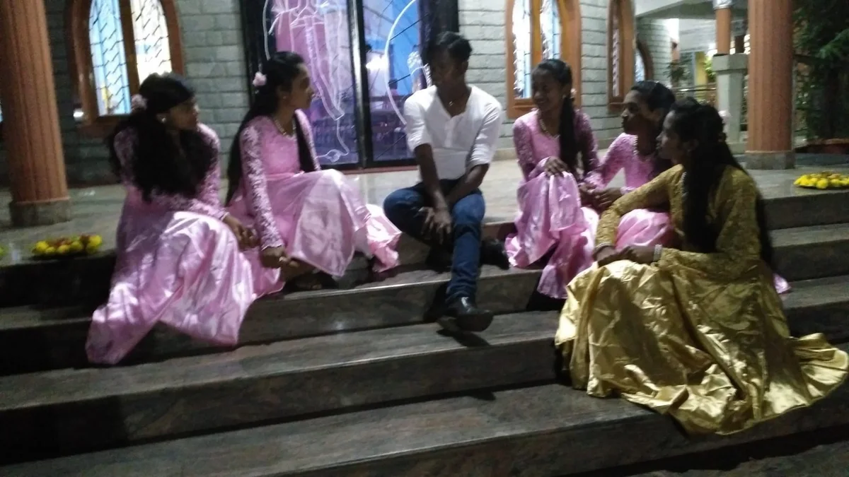 Nikhil Schmidt im Gespräch mit jungen Frauen auf einer Treppe in Indien